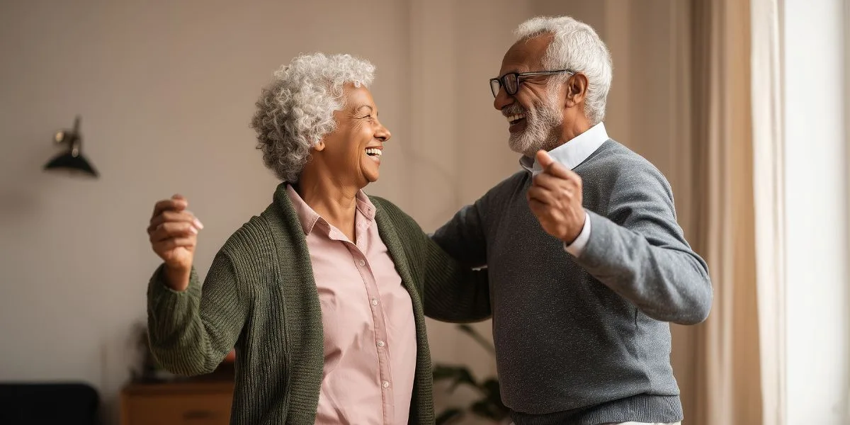 Happy couple dances in their senior living community apartment