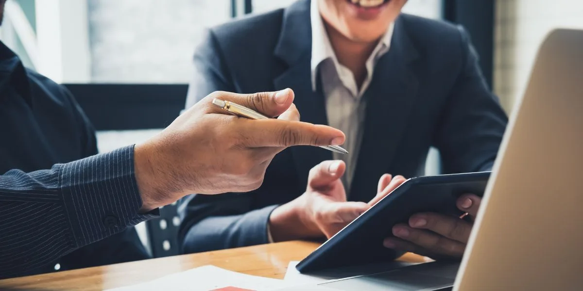 A financial advisor highlights savings and benefits to a client on his tablet.