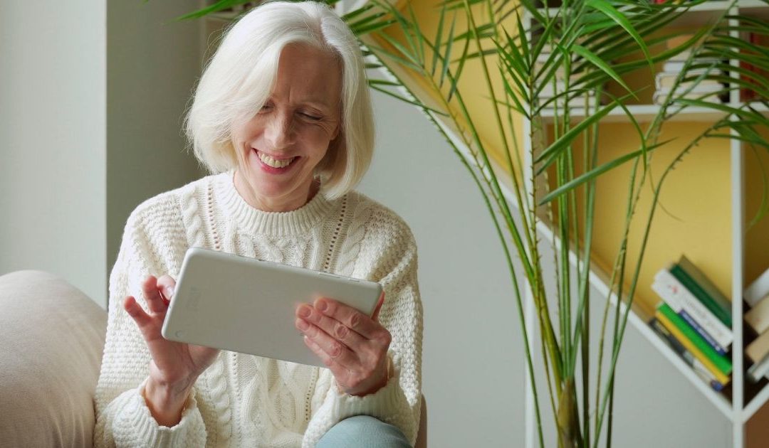 Older happy woman on a tablet