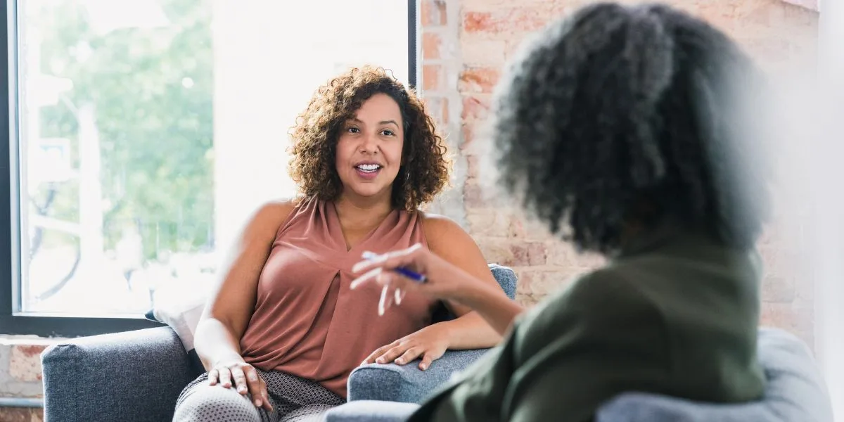 Two women sit and discuss a business relationship