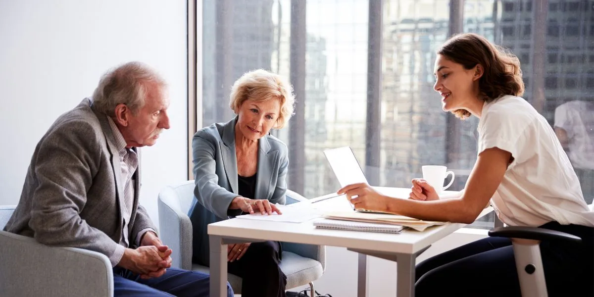 Mature couple sitting at a table with a preneed provider discussing arrangements