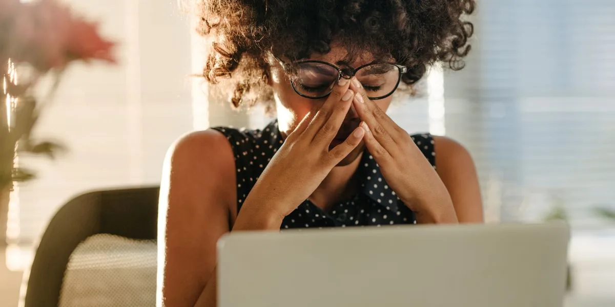 Professional woman with her hands on her face in disappointment as she works.