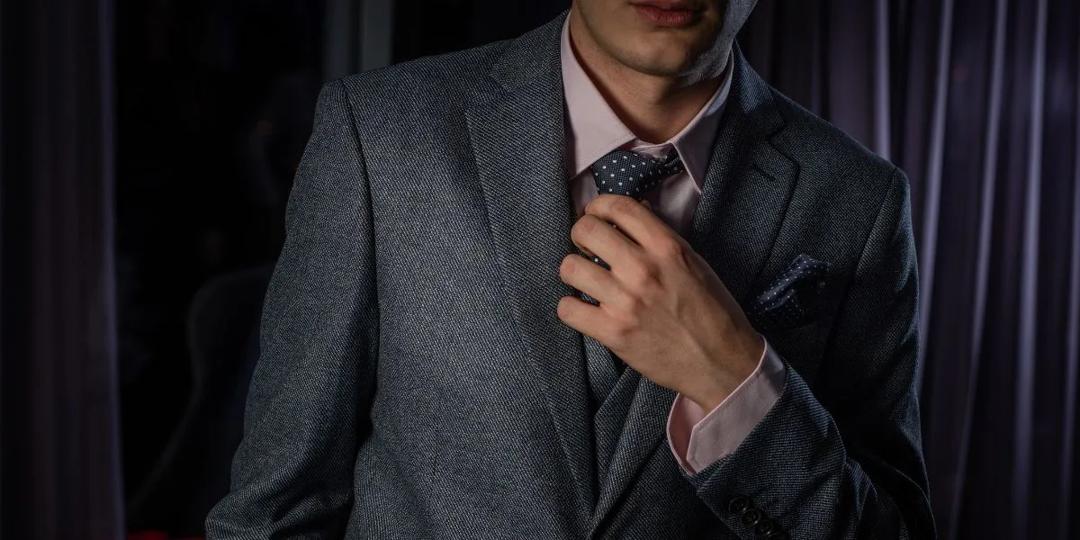 Close up of a financial professional in a suit, adjusting his tie