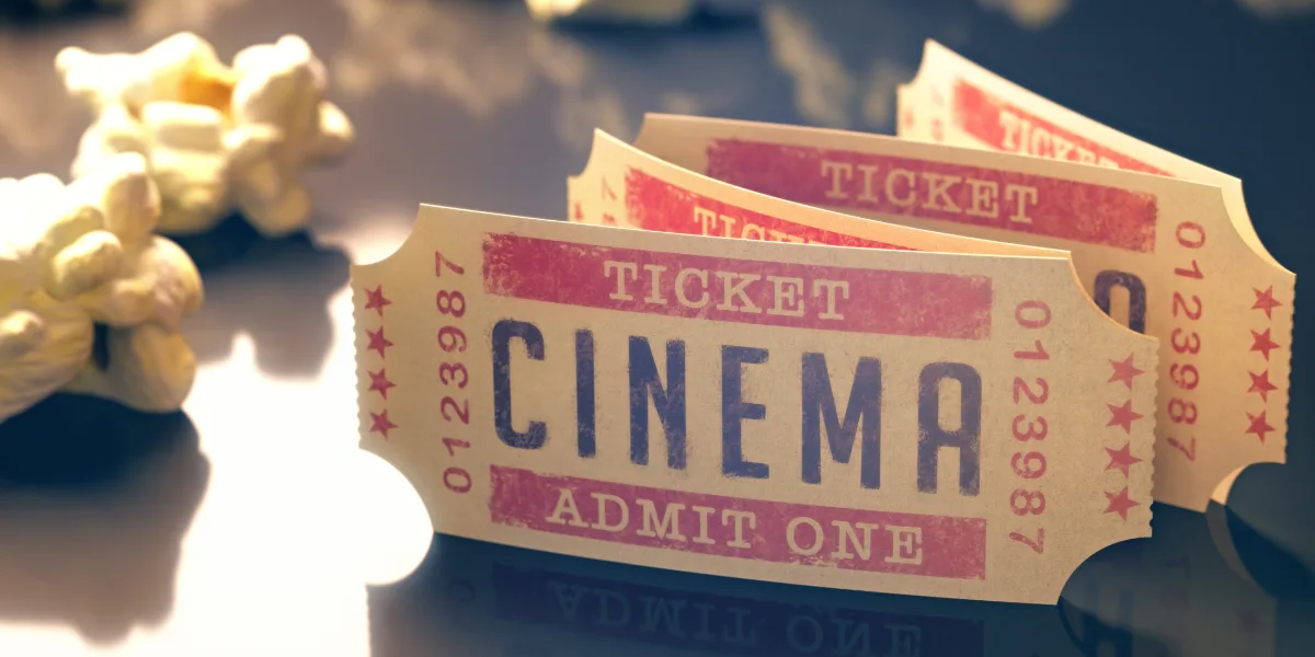 Old fashioned cinema tickets and popcorn sit on a table